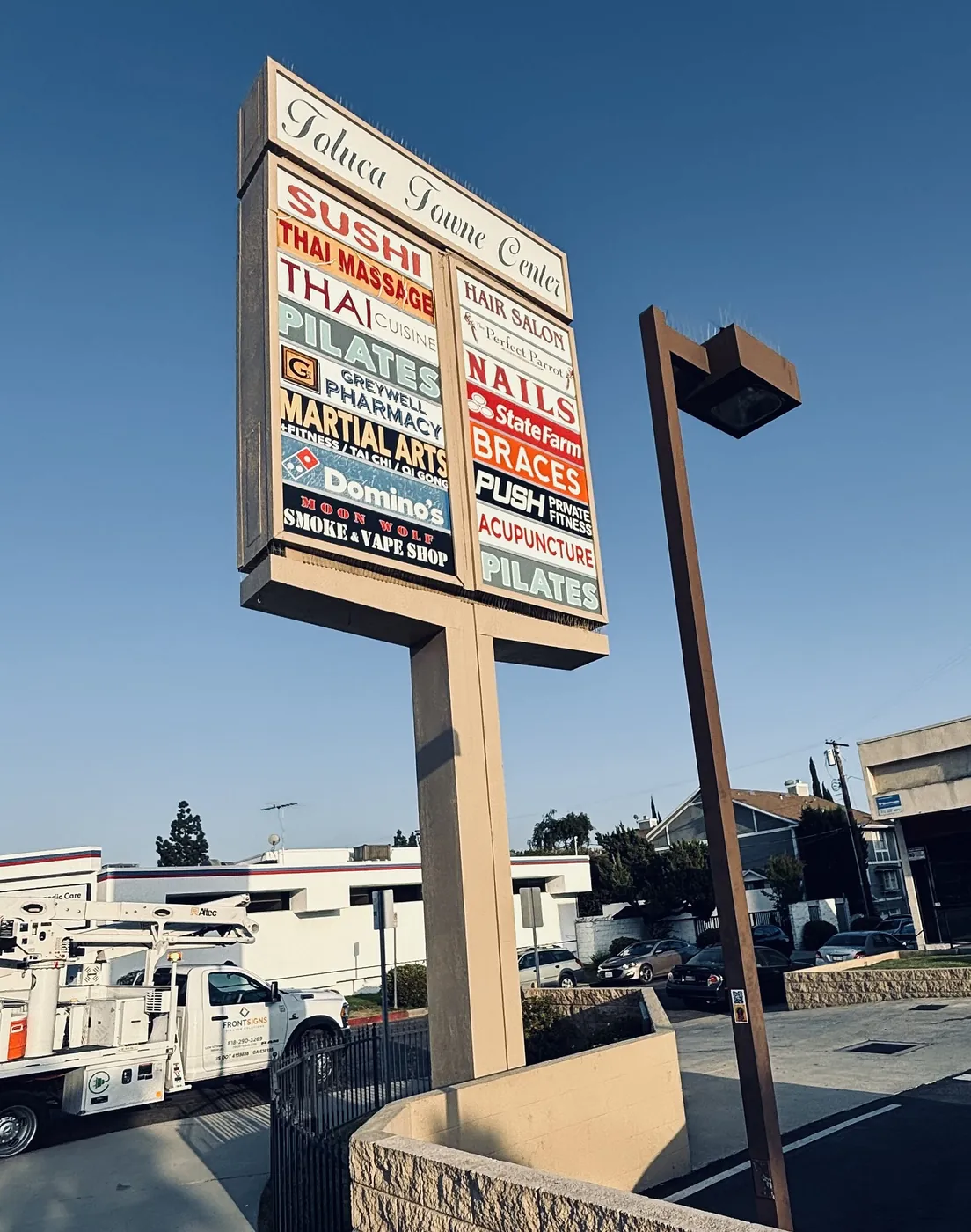 A tall pylon sign lists the shops in a town centre.