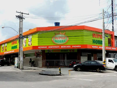 Green and orange aluminium composite panels cover a supermarket front, with letters fixed on the fascia.