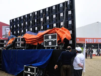 Two men check the modules on the back of an LED wall in Kolkata.