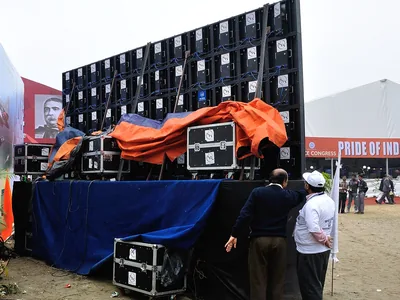 A crew stands with an LED wall while it is set up at an exhibition in Kolkata.