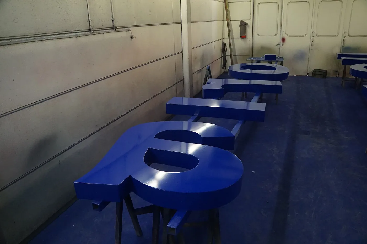 Painted dimensional letters dry in a finishing room before they are lit.