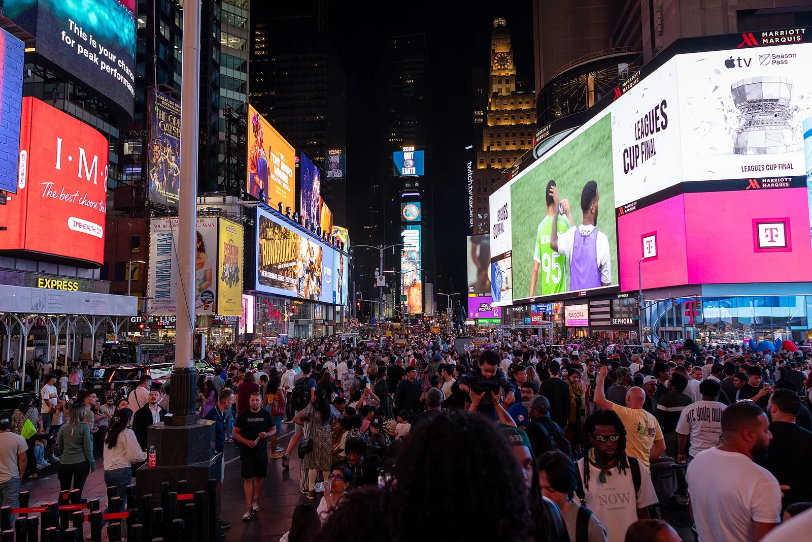 Illuminated billboards and signs cover the buildings at Times Square at night.
